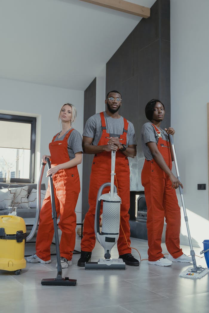 about-01 Three cleaners in uniform with equipment in a modern home interior, showcasing teamwork and professionalism.